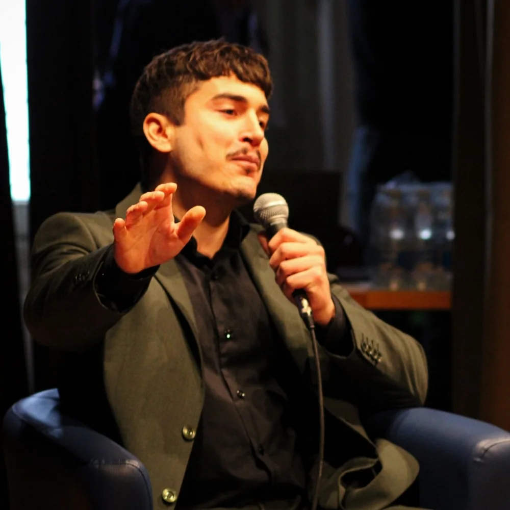 Nicholas Perpiglia speaking on stage at a business panel