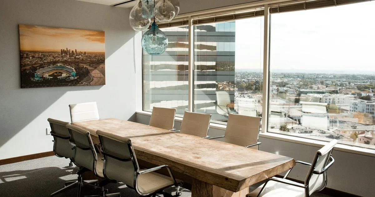 Sala riunioni con un lungo tavolo in legno affacciata sullo skyline di Londra